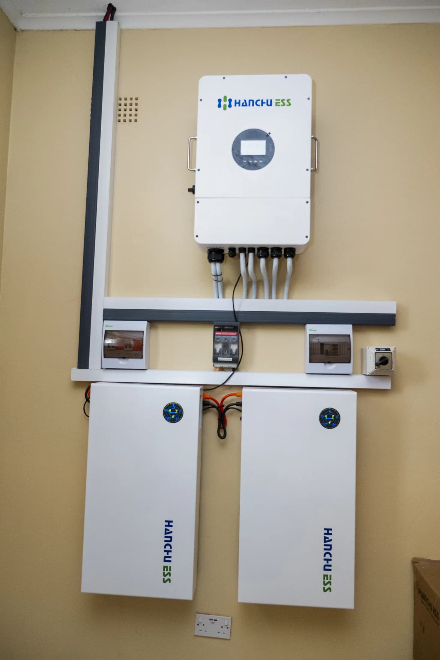 Finished 12 kW Hanchu ESS inverter above a breaker rail and two lithium battery modules